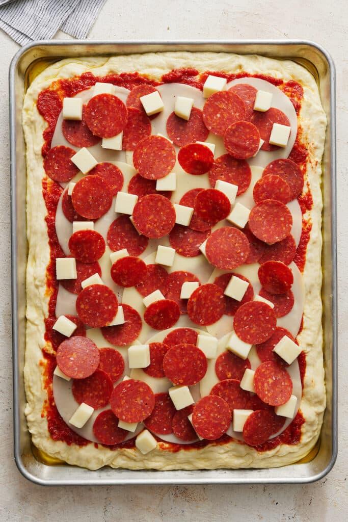 Pepperoni pizza in pizza pan ready to be baked.