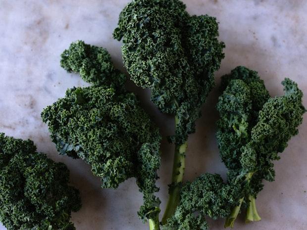 bunch of curly kale on a marble kitchen counter