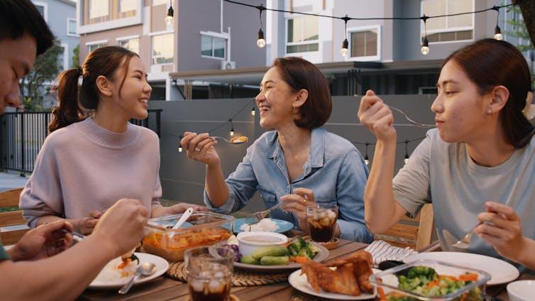 Friends eat dinner on a rooftop terrace