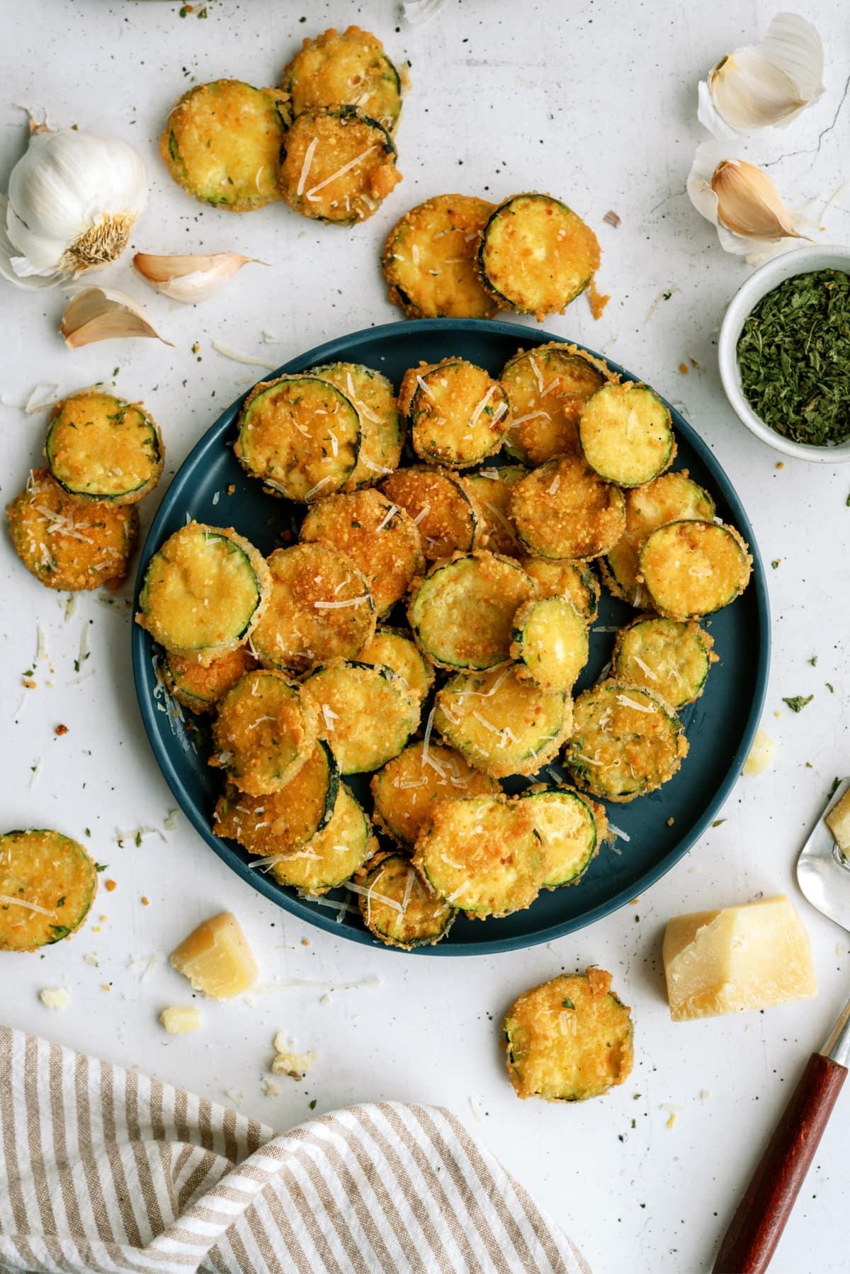 fried zucchini on white counter and green plate