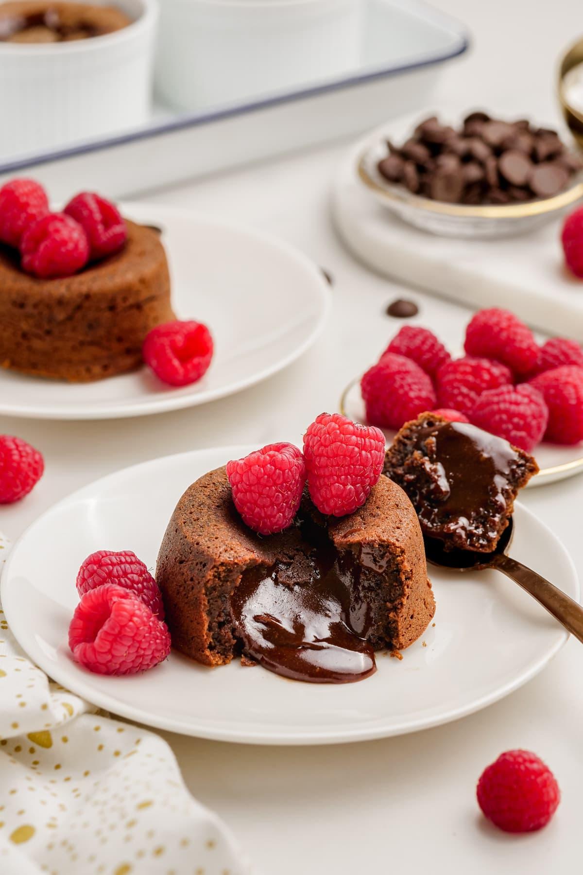 molten-lava-cake with raspberries on plates with spooned out filling