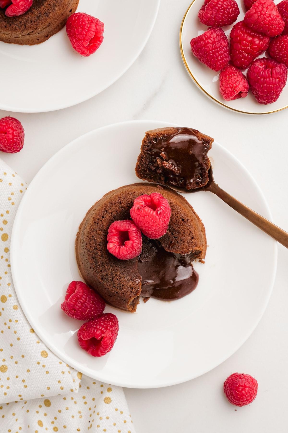 molten lava cake 16 molten-lava-cake with raspberries on plates with spooned out filling