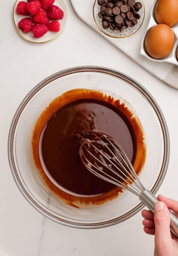molten lava cake 3 min min butter and chocolate melted in bowl with woman's hand whisking