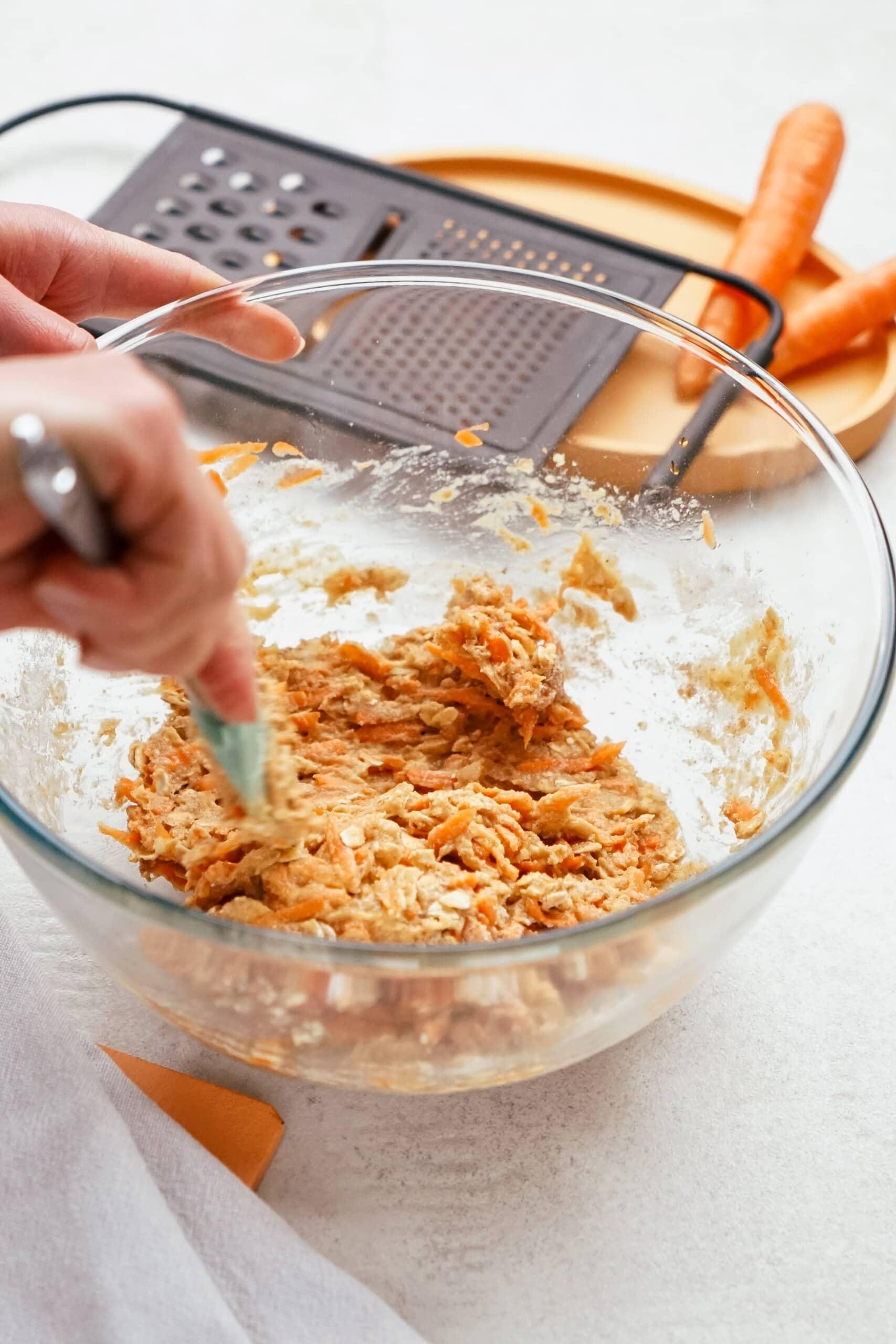 womans hand incorporating dry ingredients into wet ingredients