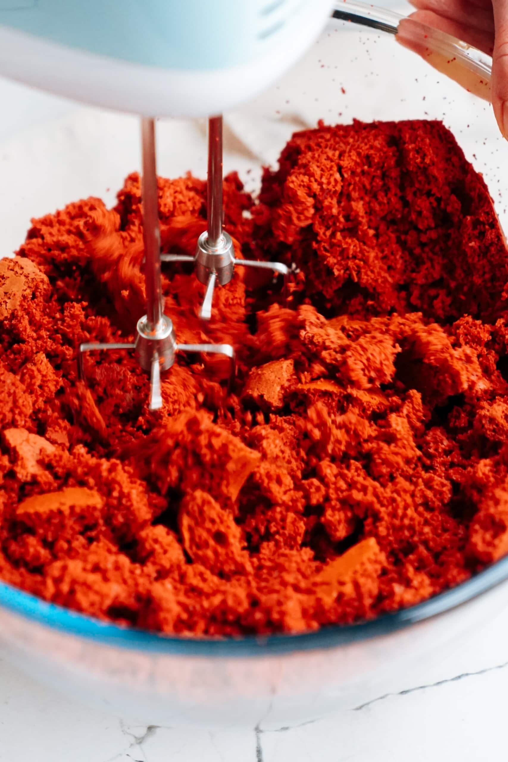 beaters mixing cake into crumbles