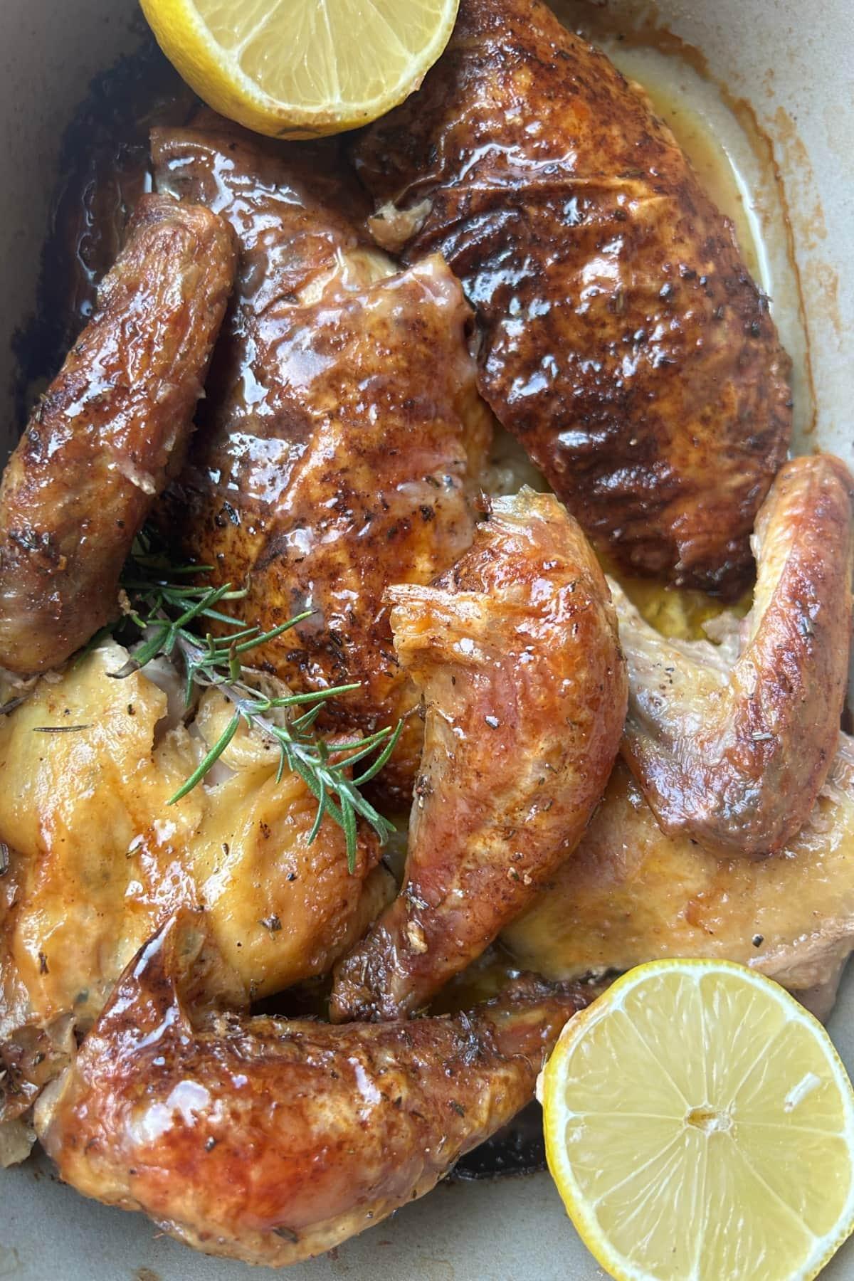 cut up sous vide spatchcock chicken in pan with lemons