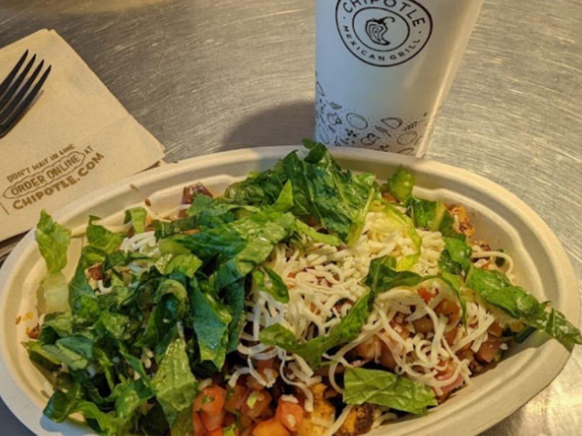 A high protein salad served with a fork alongside a cup of coffee.