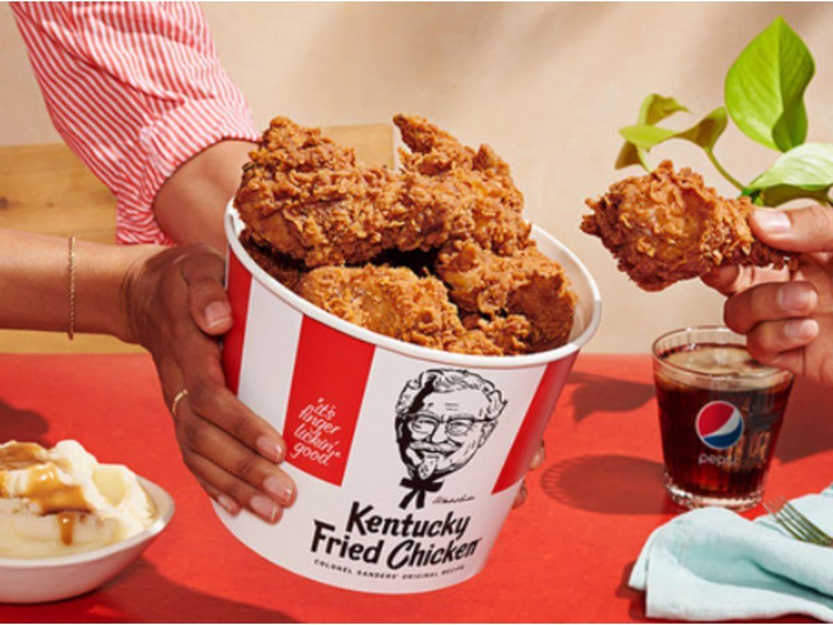 Two hands holding a bucket of protein-packed fried chicken.