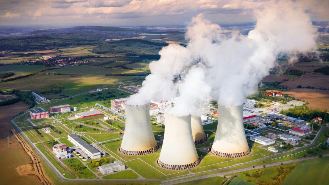 Image of three large smoke stacks with billowing smoke, showing how greenhouse gasses are released into the atmosphere and EPA emissions ruling could be overturned.